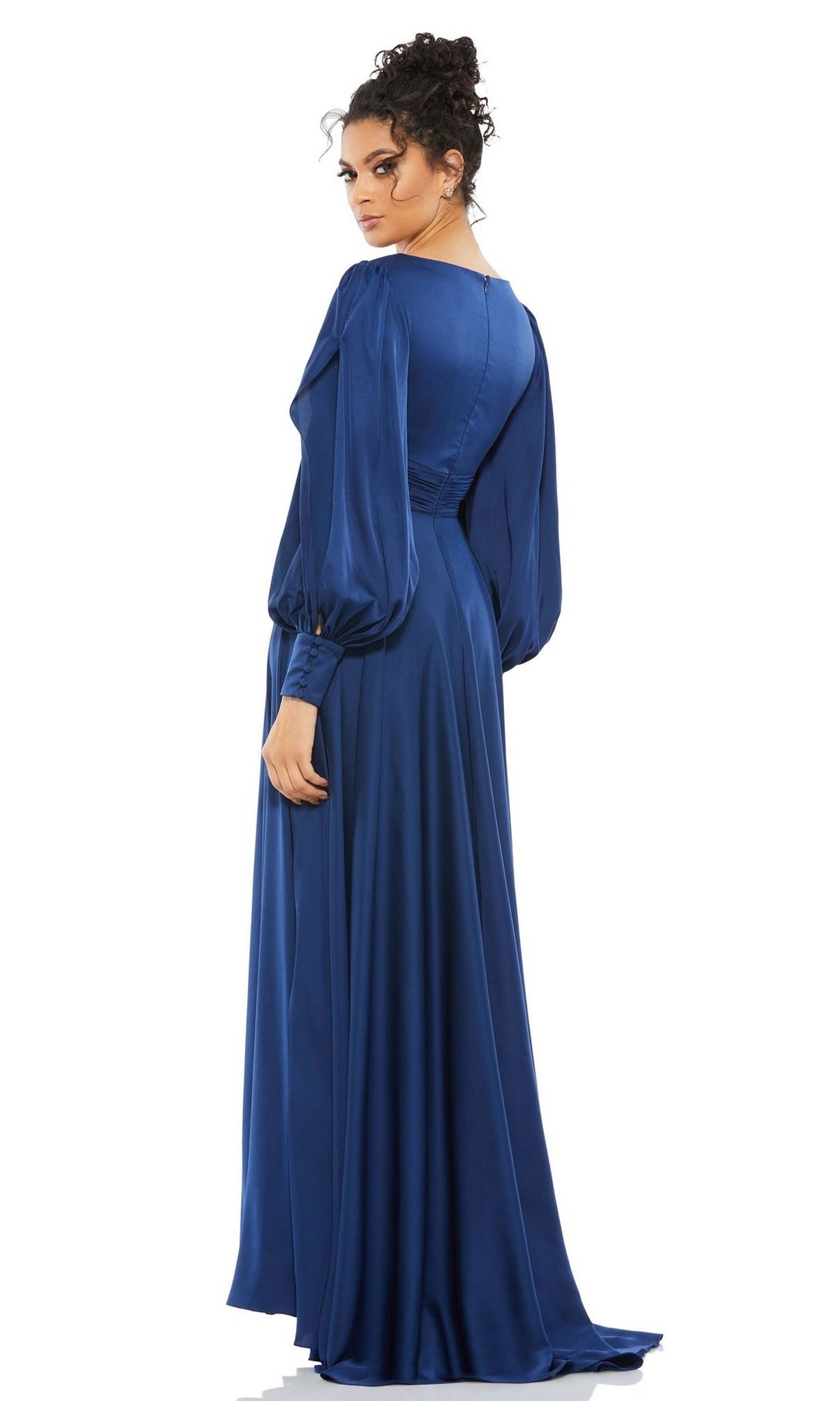 A woman stands looking over her shoulder in the Long Formal Dress 67847 by Mac Duggal, a blue gown with elegant puffed sleeves.